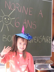 Toute belle avec son chapeau garni d'une plume rose